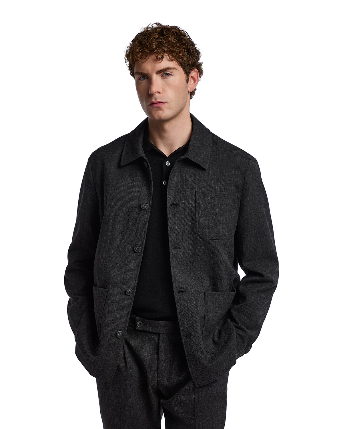 Men's black textured cotton jacket with a button-up front and side pockets, styled casually for versatile wear.