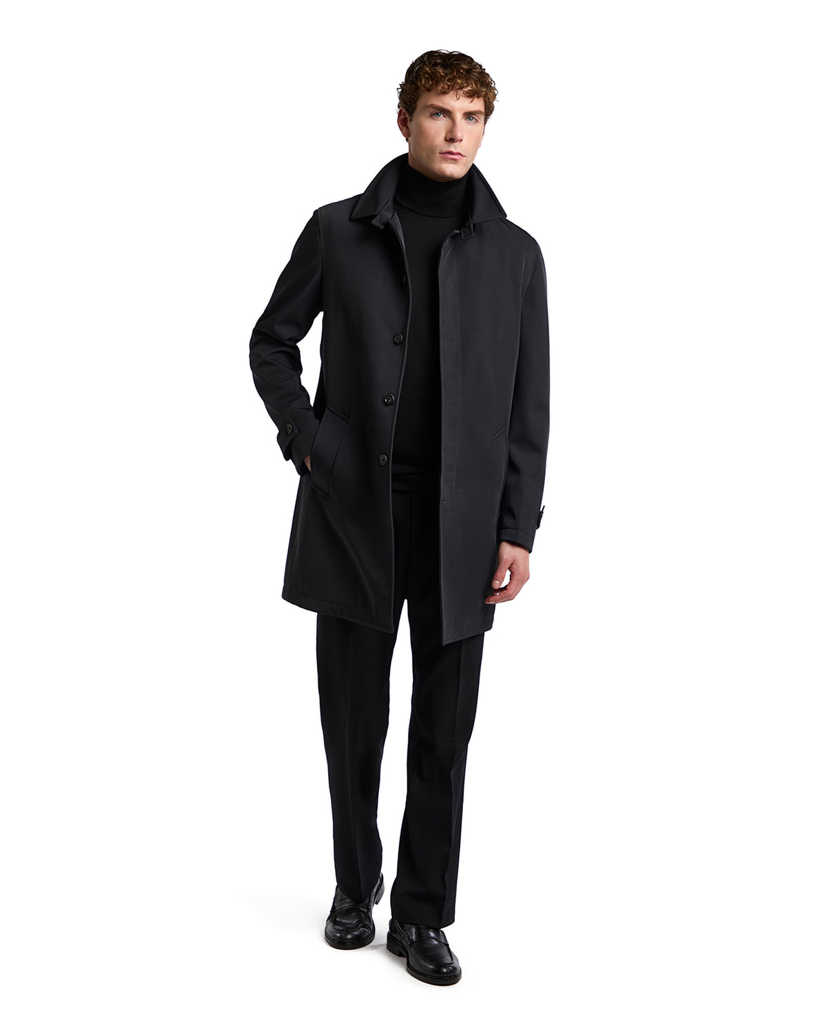 Men's black trench coat in sleek fabric, featuring a button-up front and modern silhouette, styled with black turtleneck and pants.